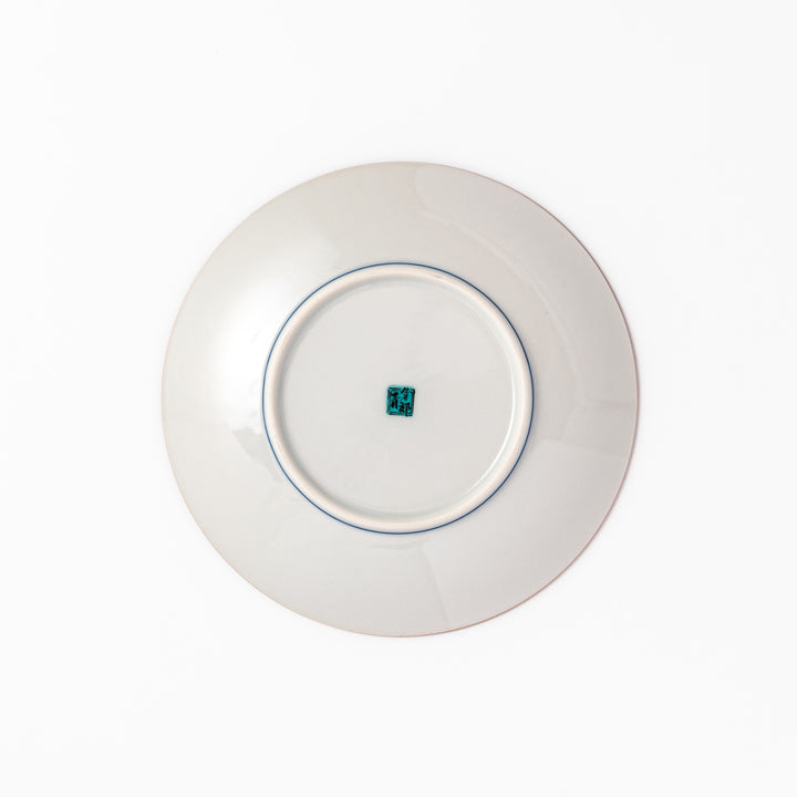 Porcelain dessert plate with bold blue peony flowers, green leaves, and a golden yellow background accented by intricate dot patterns.