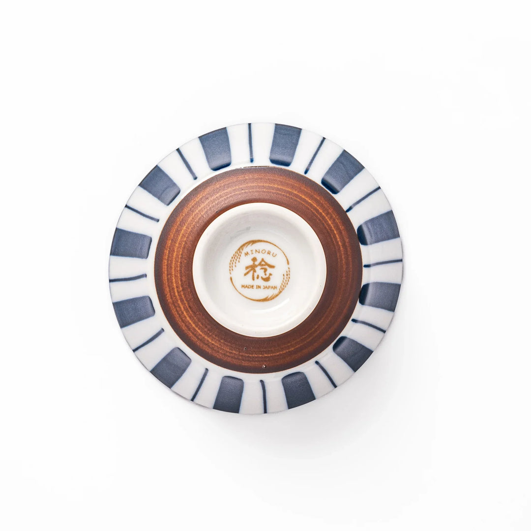 Japanese porcelain rice bowl with bold indigo and white stripe pattern and terracotta base, crafted in modern traditional style.