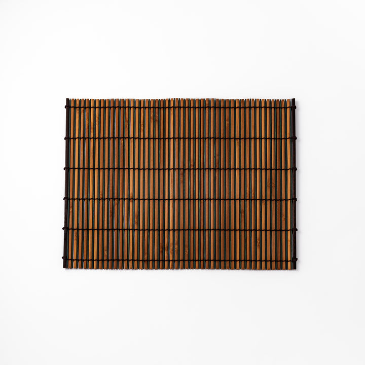 Brown bamboo table mat featuring alternating dark and natural slats bound with black cord, perfect for warm, earthy Japanese-inspired table settings.