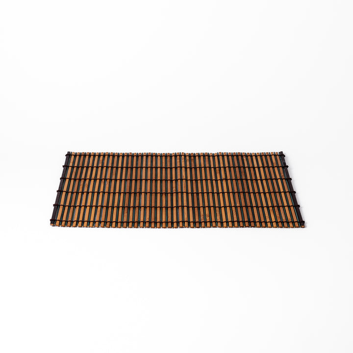 Brown bamboo table mat featuring alternating dark and natural slats bound with black cord, perfect for warm, earthy Japanese-inspired table settings.