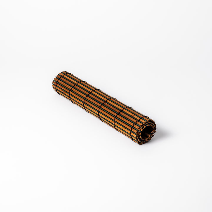 Brown bamboo table mat featuring alternating dark and natural slats bound with black cord, perfect for warm, earthy Japanese-inspired table settings.