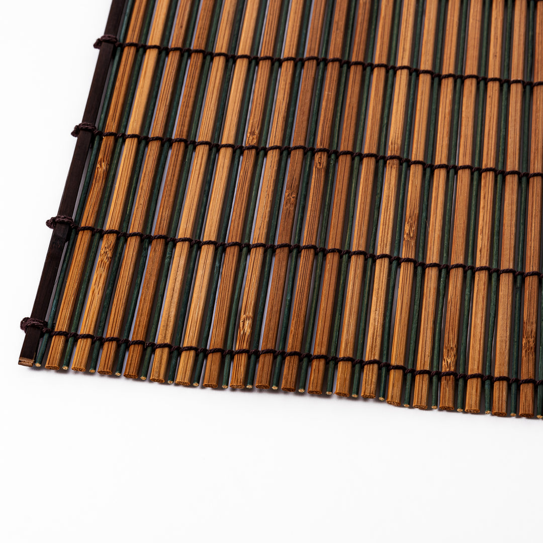 Brown bamboo table mat featuring alternating dark and natural slats bound with black cord, perfect for warm, earthy Japanese-inspired table settings.