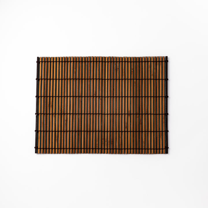 Brown bamboo table mat featuring alternating dark and natural slats bound with black cord, perfect for warm, earthy Japanese-inspired table settings.