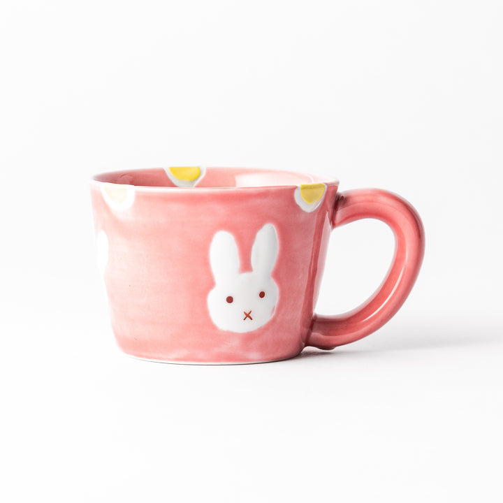 Adorable pink kids' mug featuring a cute bunny design and yellow accents, perfect for young children and adding a fun touch to mealtime.