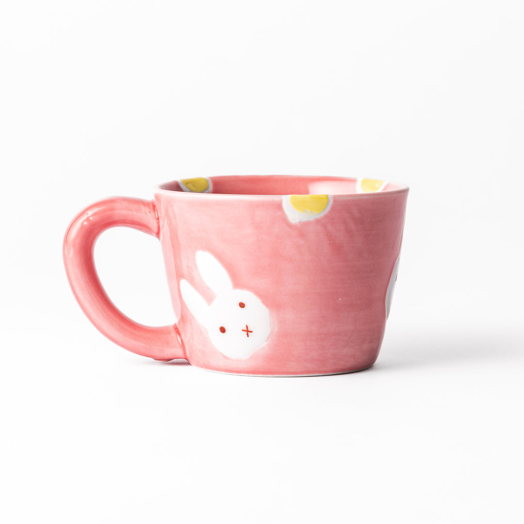 Adorable pink kids' mug featuring a cute bunny design and yellow accents, perfect for young children and adding a fun touch to mealtime.