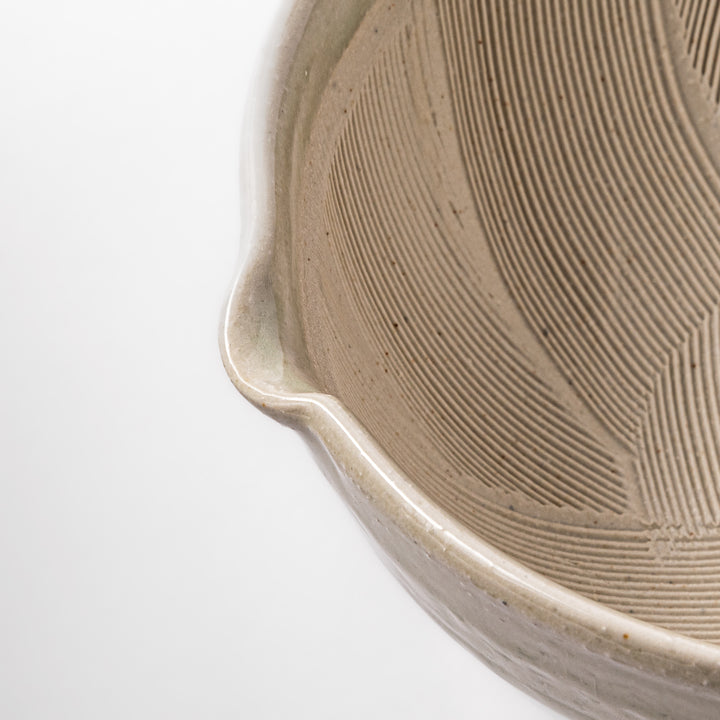 Celadon green Japanese suribachi mortar with finely grooved interior and pouring spout, perfect for grinding sesame seeds and preparing traditional sauces.