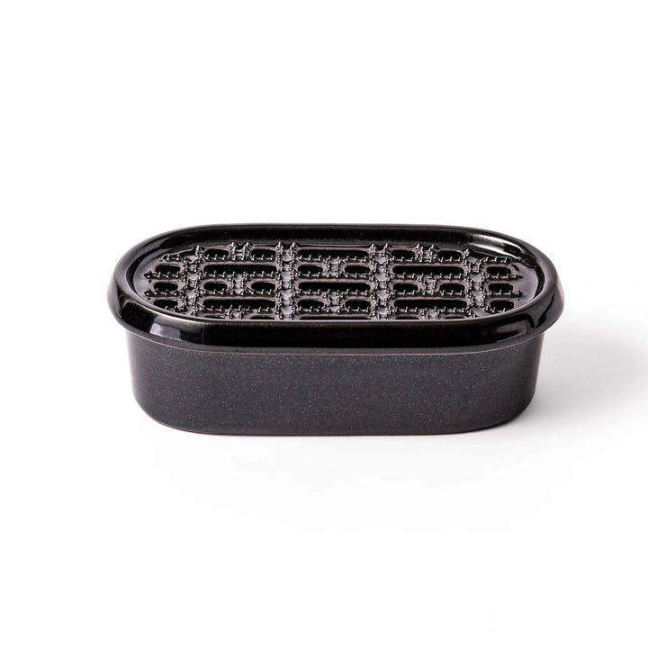 Black ceramic daikon oroshi grater with built-in serving dish, featuring wide grating holes and textured surface for smooth grating and easy cleanup.