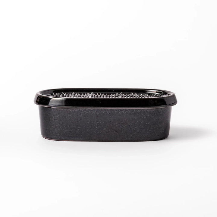 Black ceramic daikon oroshi grater with built-in serving dish, featuring wide grating holes and textured surface for smooth grating and easy cleanup.