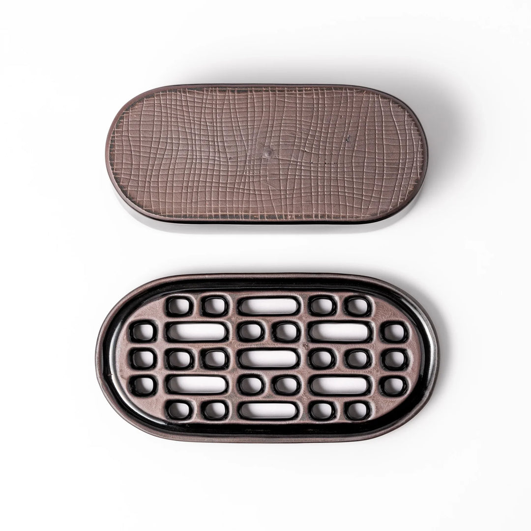 Black ceramic daikon oroshi grater with built-in serving dish, featuring wide grating holes and textured surface for smooth grating and easy cleanup.