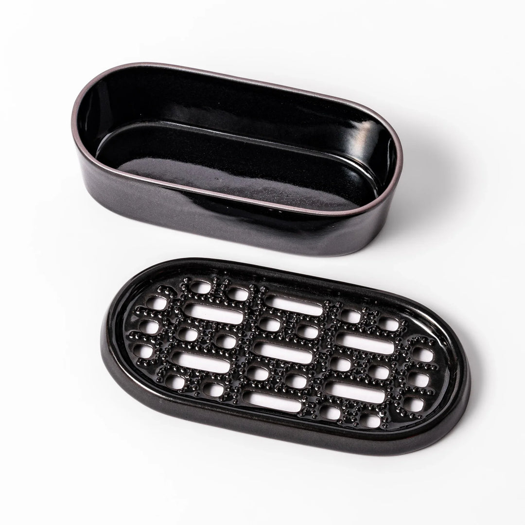 Black ceramic daikon oroshi grater with built-in serving dish, featuring wide grating holes and textured surface for smooth grating and easy cleanup.