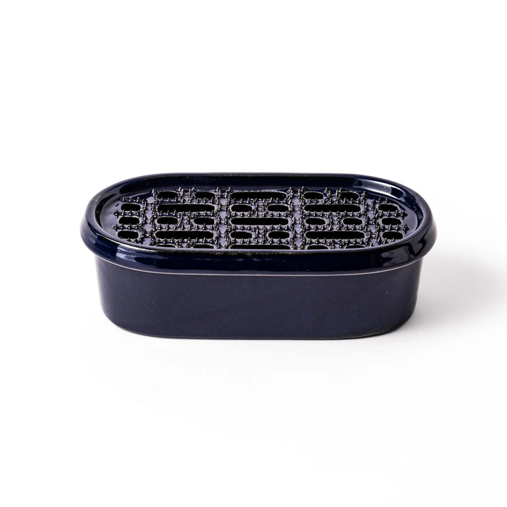 Deep blue ceramic daikon oroshi grater with an integrated serving dish, featuring wide grating holes and raised texture for easy grating and cleanup.