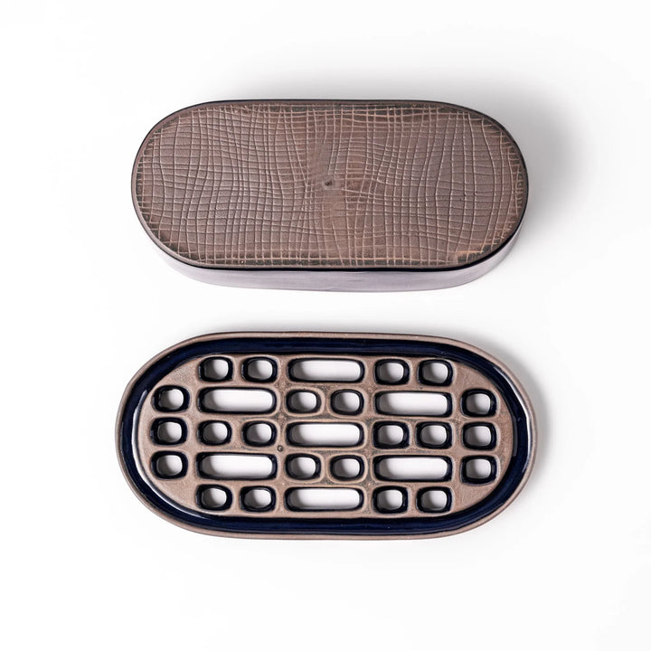 Deep blue ceramic daikon oroshi grater with an integrated serving dish, featuring wide grating holes and raised texture for easy grating and cleanup.