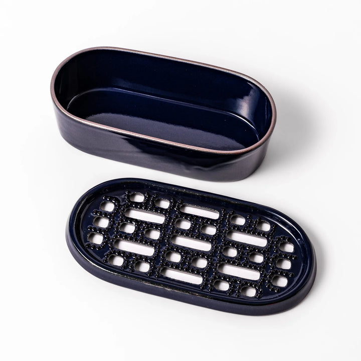 Deep blue ceramic daikon oroshi grater with an integrated serving dish, featuring wide grating holes and raised texture for easy grating and cleanup.