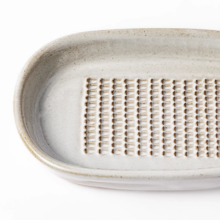 White ceramic ginger grater dish with a natural glaze and raised teeth, ideal for finely grating ginger, garlic, or wasabi with minimal effort.