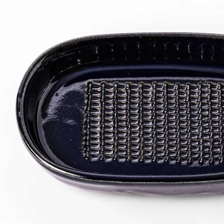 Deep blue ceramic ginger grater dish with raised teeth and a shallow base, designed for efficiently grating ginger, garlic, or daikon.