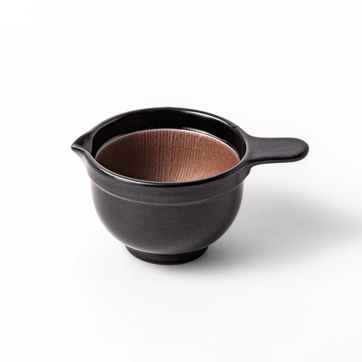Black ceramic natto suribachi bowl with a ridged brown interior and side handle, ideal for grinding and mixing natto or other small ingredients.