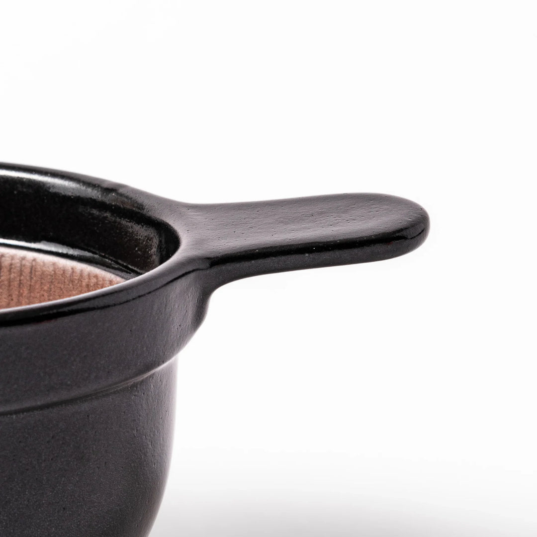 Black ceramic natto suribachi bowl with a ridged brown interior and side handle, ideal for grinding and mixing natto or other small ingredients.