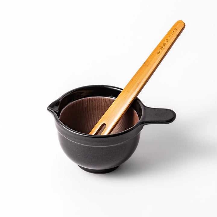 Black ceramic natto suribachi bowl with a ridged brown interior and side handle, ideal for grinding and mixing natto or other small ingredients.