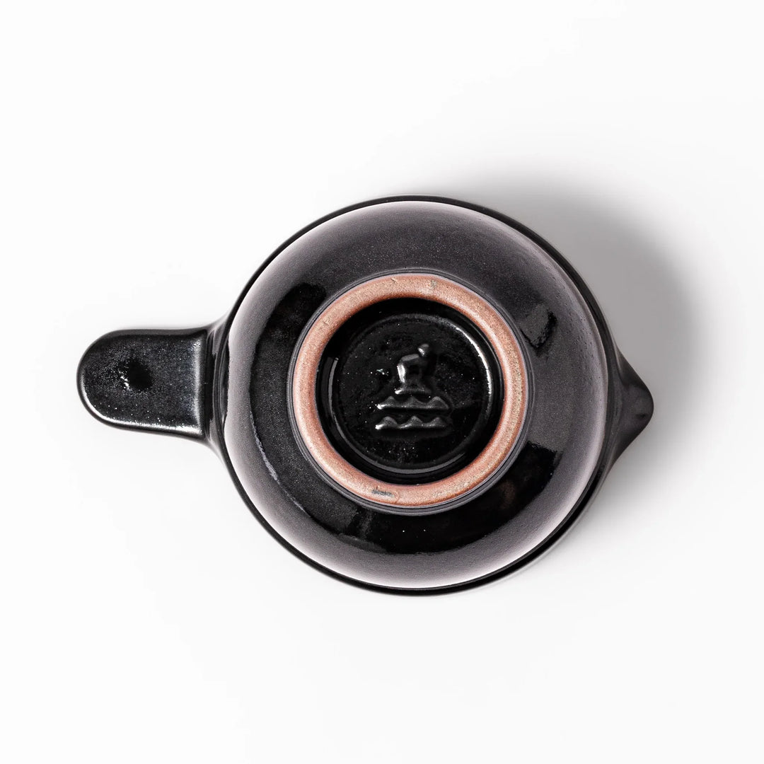 Black ceramic natto suribachi bowl with a ridged brown interior and side handle, ideal for grinding and mixing natto or other small ingredients.