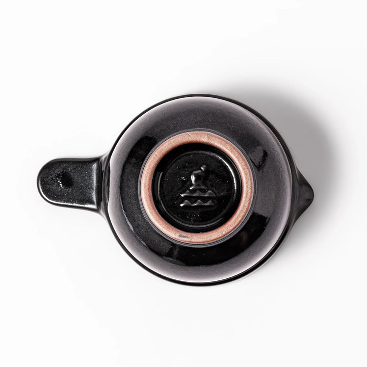 Black ceramic natto suribachi bowl with a ridged brown interior and side handle, ideal for grinding and mixing natto or other small ingredients.