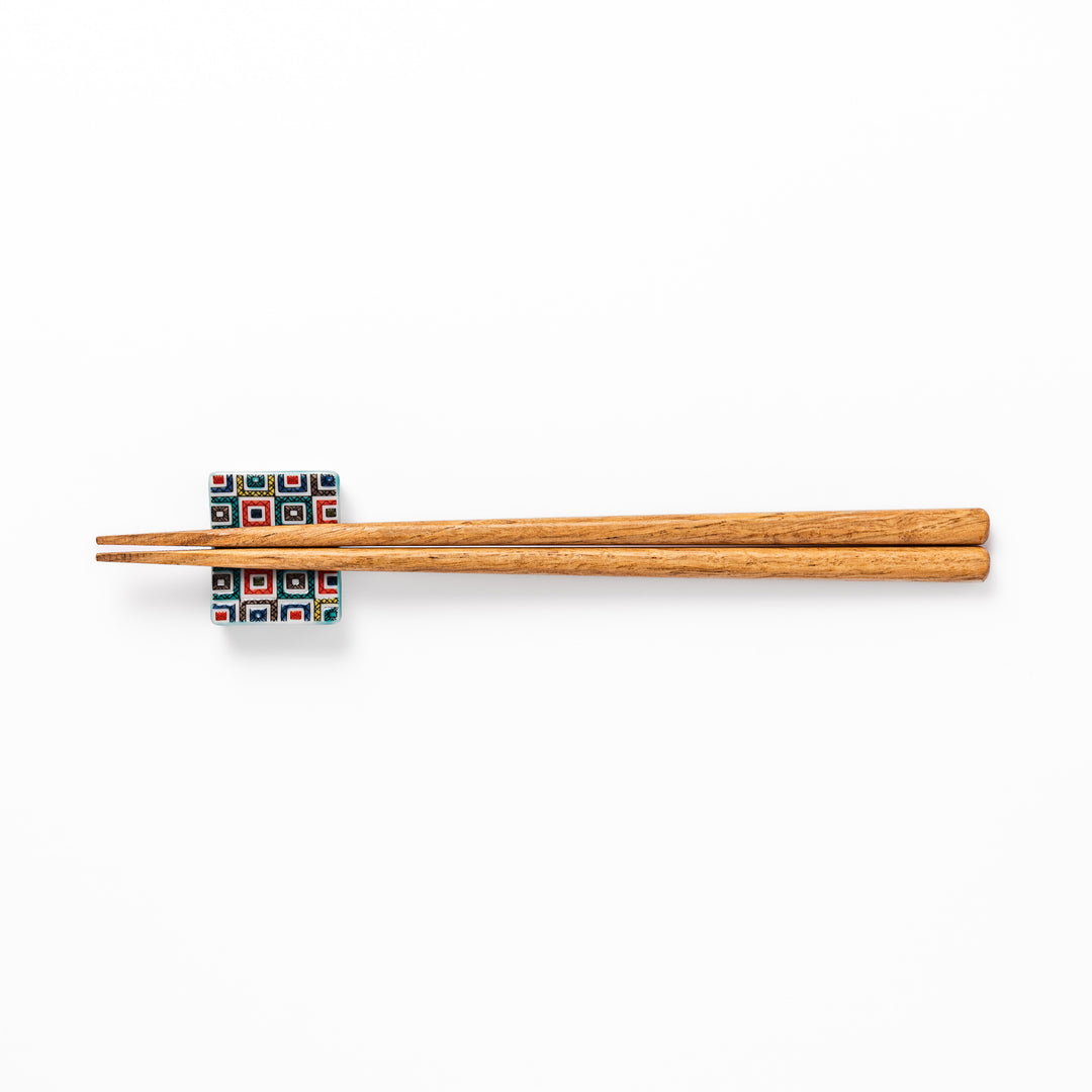 Japanese ceramic chopstick rest with colorful cobblestone mosaic pattern in red, blue, green, yellow, and black, adding elegance to any dining table.