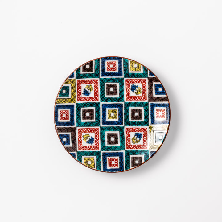 Colorful porcelain dessert plate featuring a mosaic of geometric square patterns in red, green, yellow, blue, and black with floral accents.