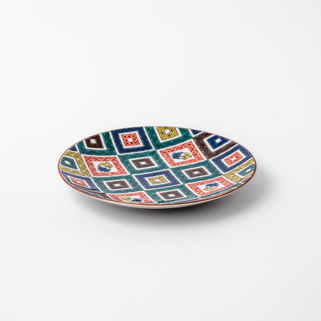 Colorful porcelain dessert plate featuring a mosaic of geometric square patterns in red, green, yellow, blue, and black with floral accents.