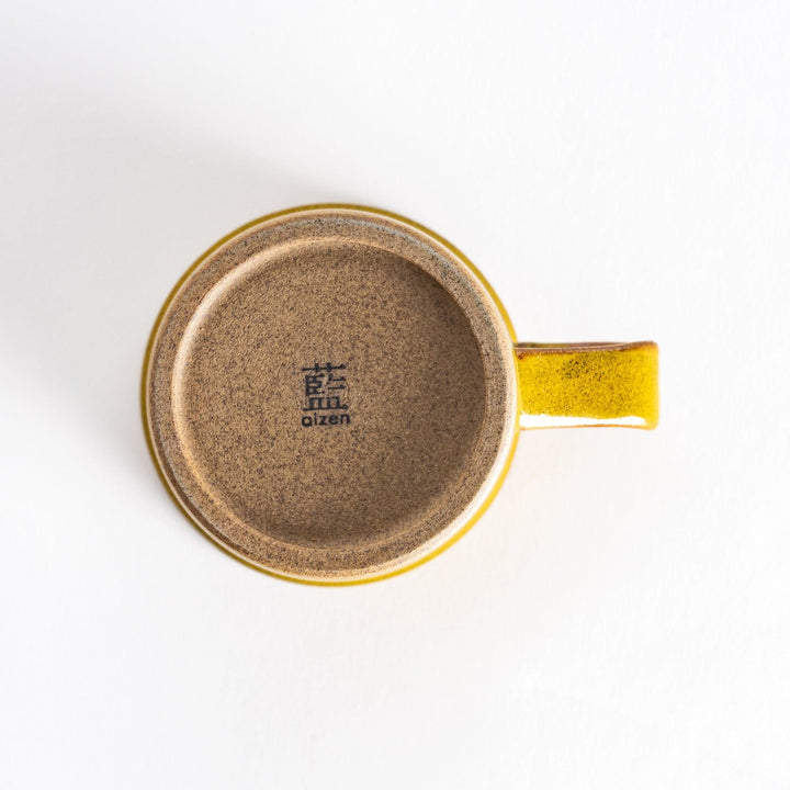 Bottom view of a yellow ceramic mug featuring a neutral-toned base with a subtle texture that complements the bright yellow glaze.