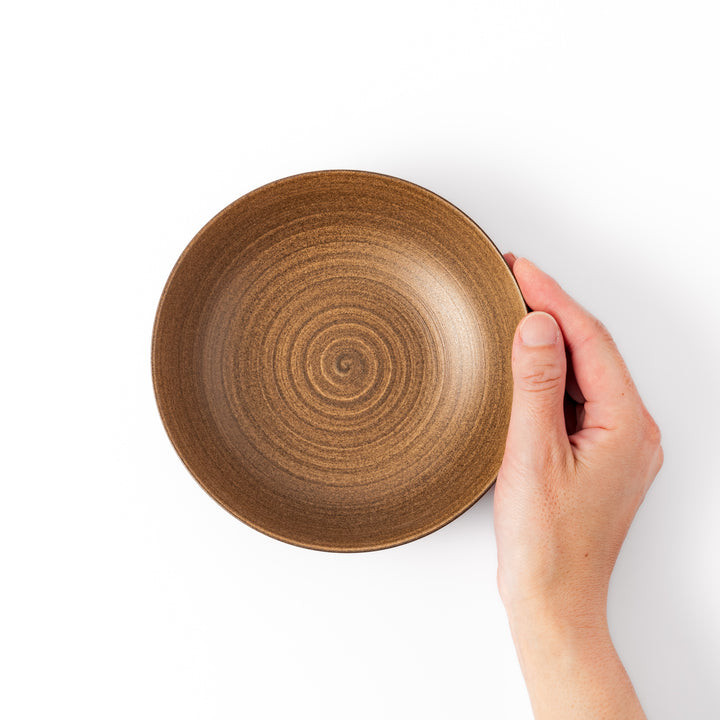 Matte beige ceramic bowl with a warm, woodgrain-like texture and softly curved shape, set against a white background.