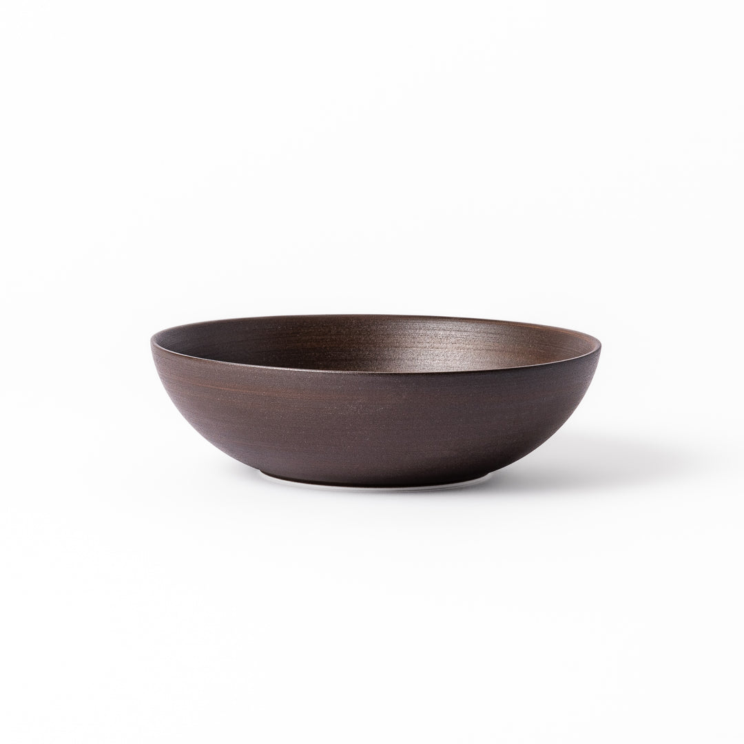 Matte brown ceramic bowl with a gently curved form and subtle textured finish, placed on a white background.