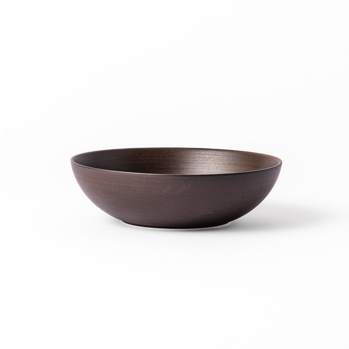 Matte brown ceramic bowl with a gently curved form and subtle textured finish, placed on a white background.