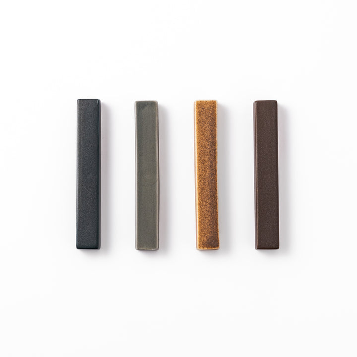 Rectangular ceramic chopstick rests in four earthy Japandi tones arranged diagonally in navy, gray, beige, and brown