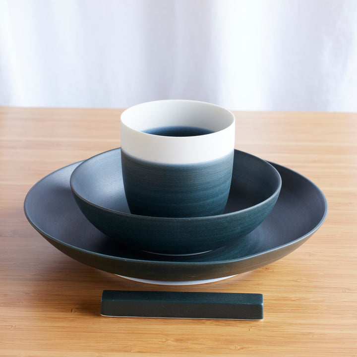 Cozy Japandi 4-Piece Dinnerware Set in navy blue gradient, featuring cup, bowl, plate, and chopstick rest on a wooden surface.