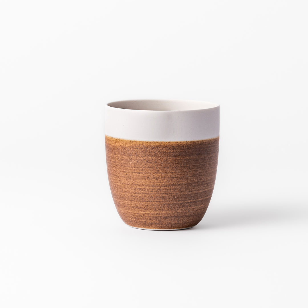 Two-tone ceramic tea cup with a matte ivory rim and warm caramel-toned base. Perfect for cozy sips and Japandi-style tables.









