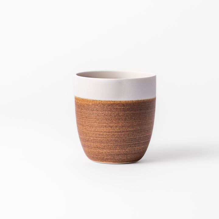 Two-tone ceramic tea cup with a matte ivory rim and warm caramel-toned base. Perfect for cozy sips and Japandi-style tables.









