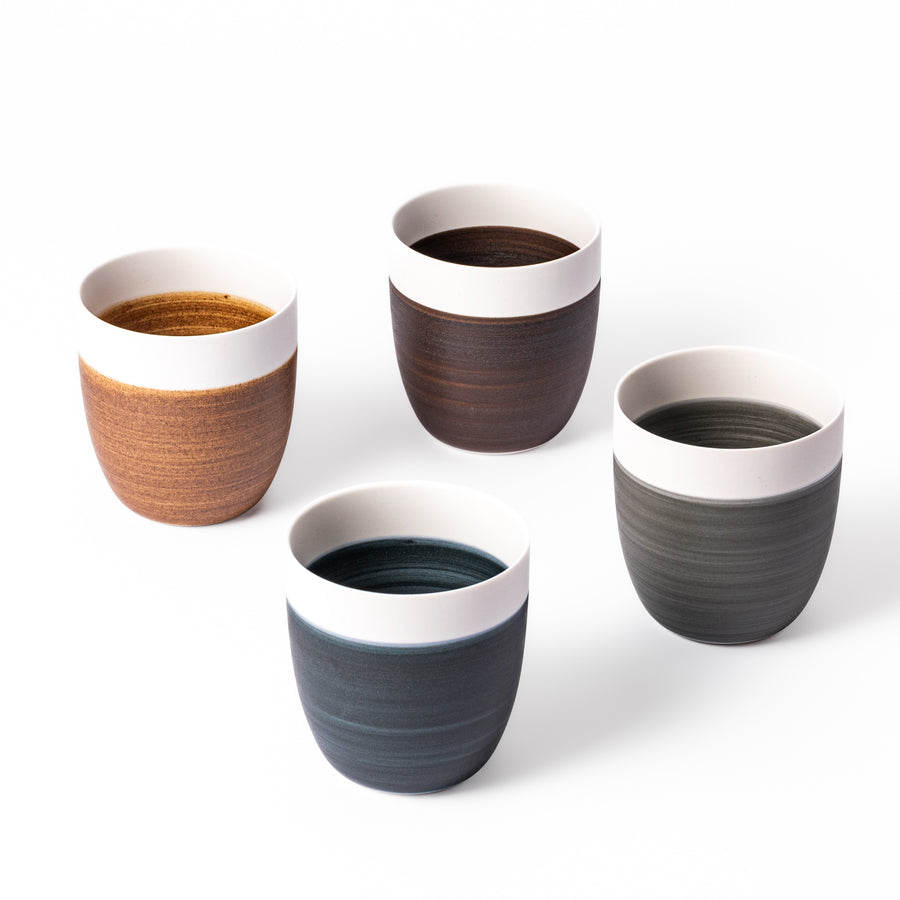 Set of four Japandi-style tea cups featuring matte ivory rims and warm earthy tones—ideal for cozy tea moments and minimal interiors.