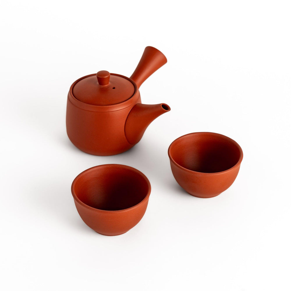 Elegant crimson tea set featuring a round teapot with spout and matching bowls, perfect for enjoying your favorite tea with style.