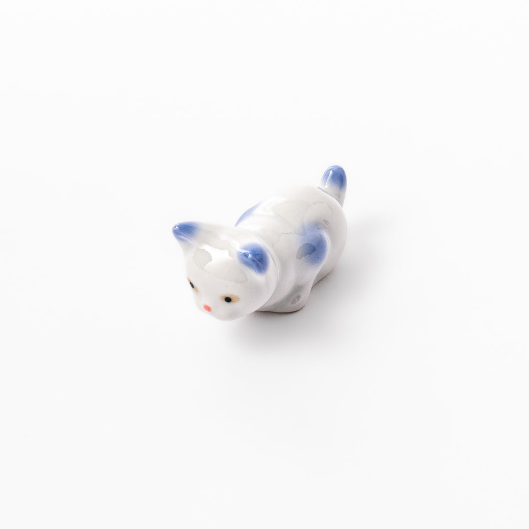White porcelain kitten-shaped chopstick rest with blue-tipped ears, tail, and body accents, featuring a small red nose.