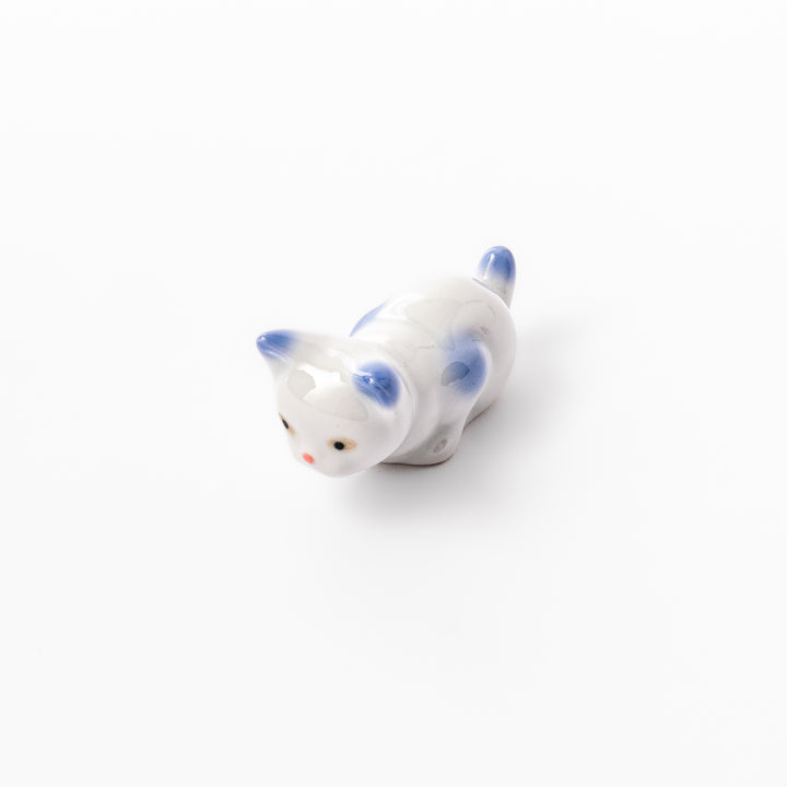 White porcelain kitten-shaped chopstick rest with blue-tipped ears, tail, and body accents, featuring a small red nose.