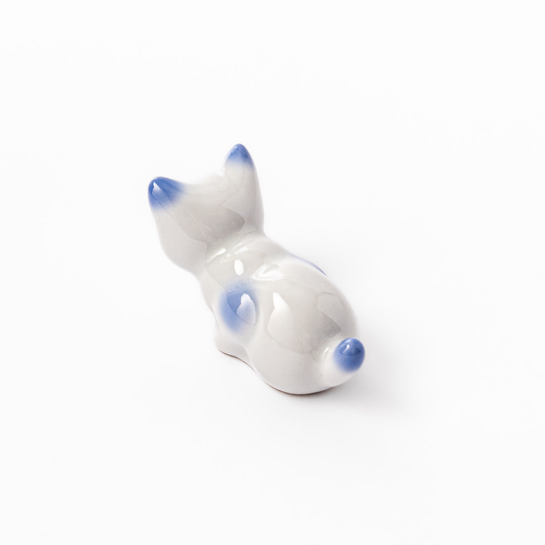 White porcelain kitten-shaped chopstick rest with blue-tipped ears, tail, and body accents, featuring a small red nose.