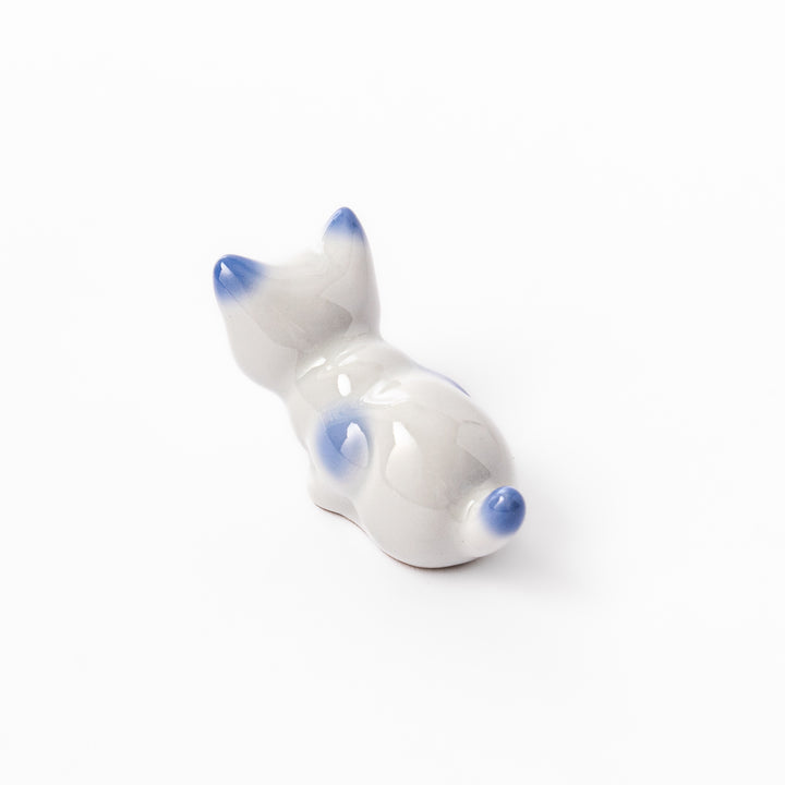 White porcelain kitten-shaped chopstick rest with blue-tipped ears, tail, and body accents, featuring a small red nose.