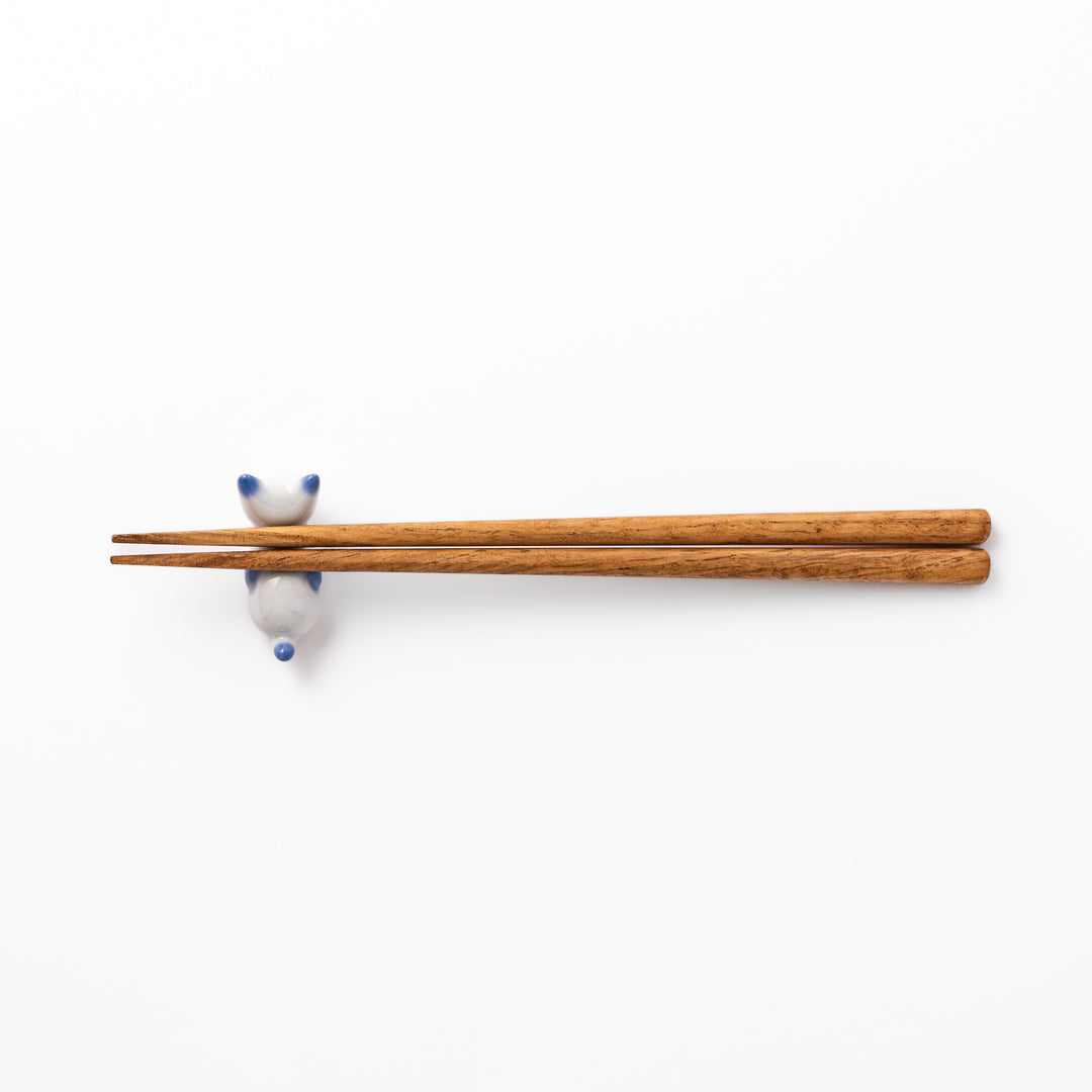White porcelain kitten-shaped chopstick rest with blue-tipped ears, tail, and body accents, featuring a small red nose.