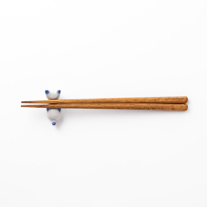 White porcelain kitten-shaped chopstick rest with blue-tipped ears, tail, and body accents, featuring a small red nose.