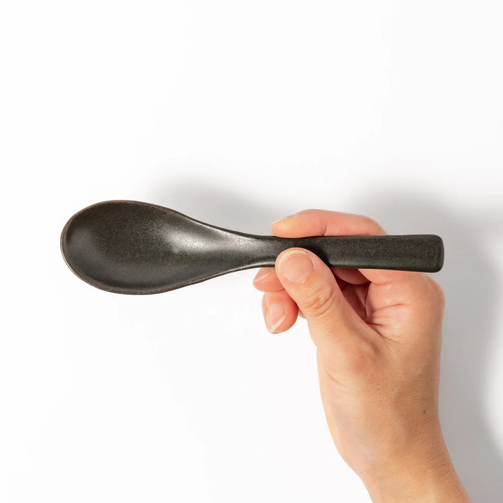 Black ceramic spoon with a smooth, rounded bowl and straight handle, ideal for serving soups, stews, or curry with refined simplicity.