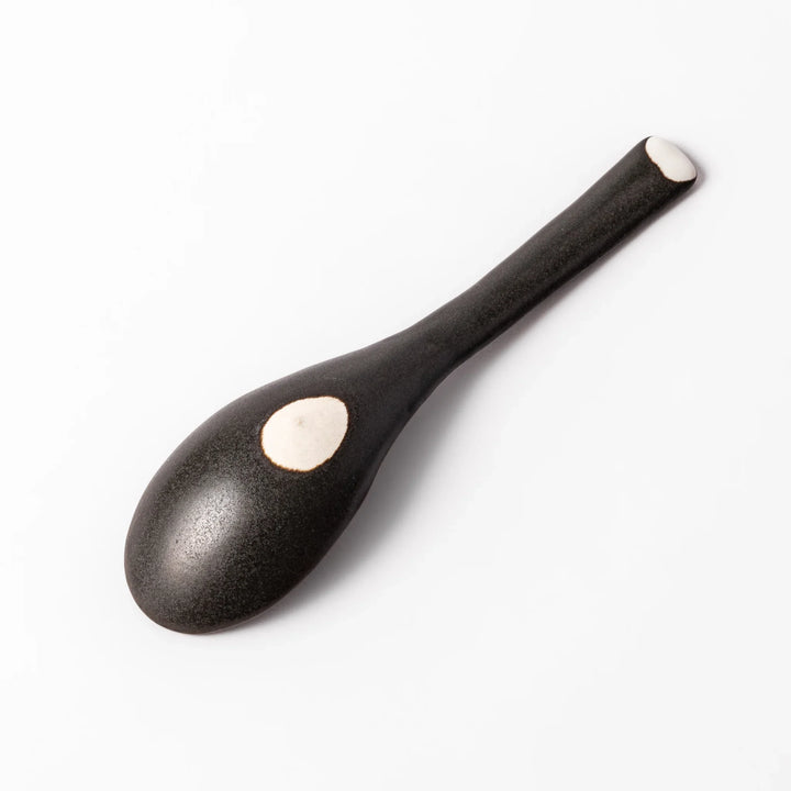 Black ceramic spoon with a smooth, rounded bowl and straight handle, ideal for serving soups, stews, or curry with refined simplicity.