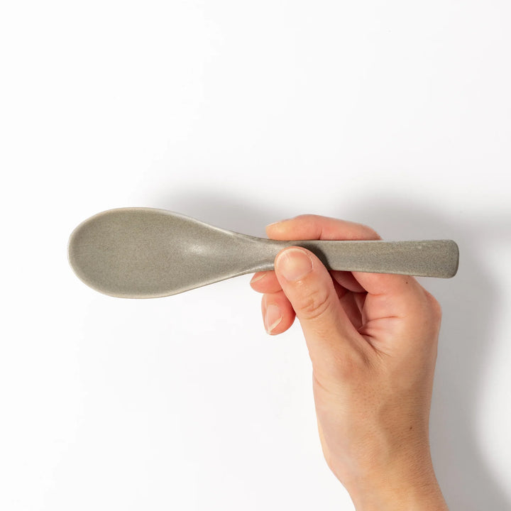 Gray ceramic spoon with a wide, curved bowl and gently angled handle, designed for smooth scooping of soups, stews, and curry dishes.