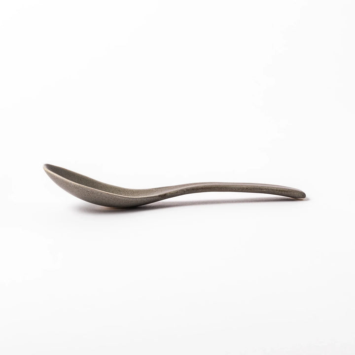 Gray ceramic spoon with a wide, curved bowl and gently angled handle, designed for smooth scooping of soups, stews, and curry dishes.