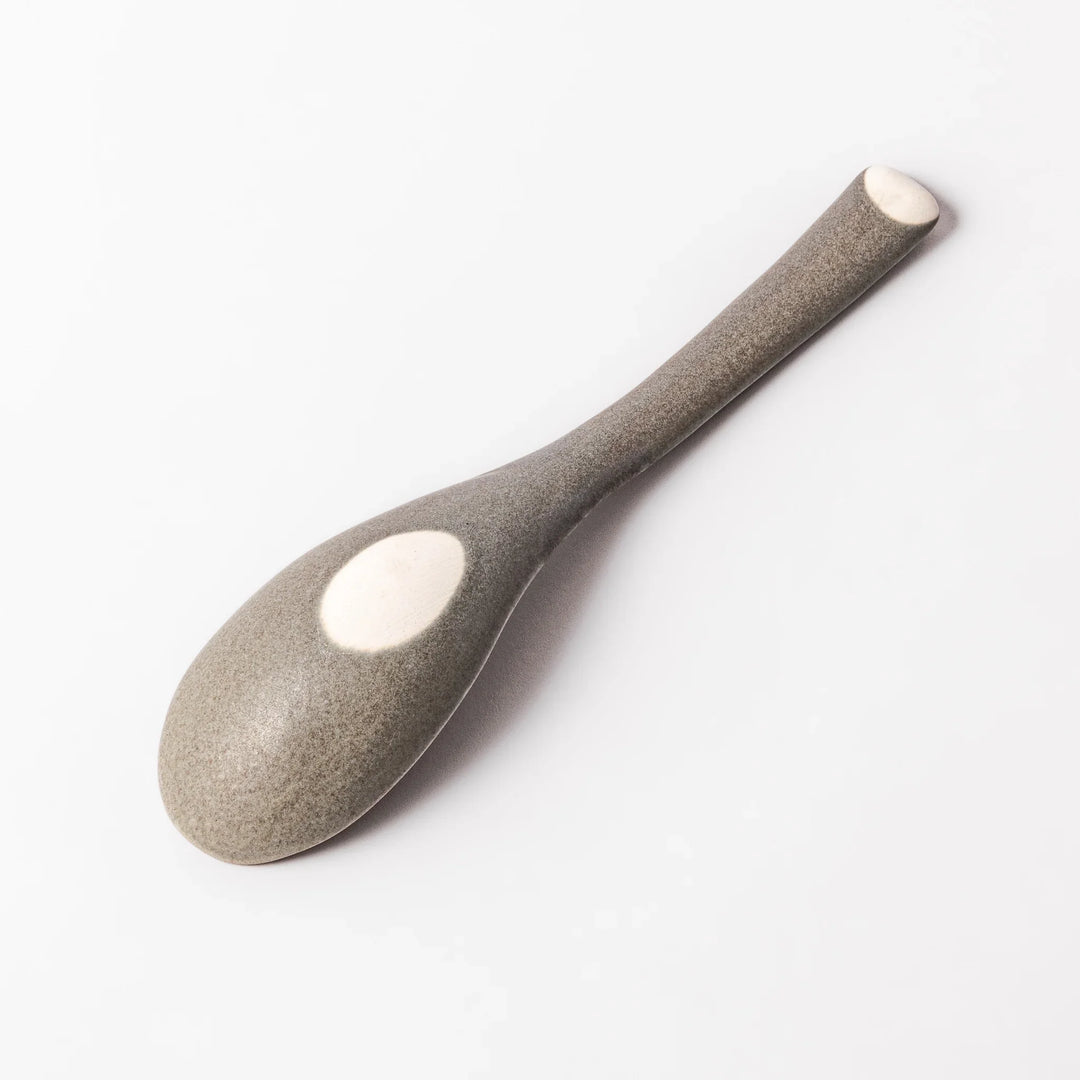 Gray ceramic spoon with a wide, curved bowl and gently angled handle, designed for smooth scooping of soups, stews, and curry dishes.