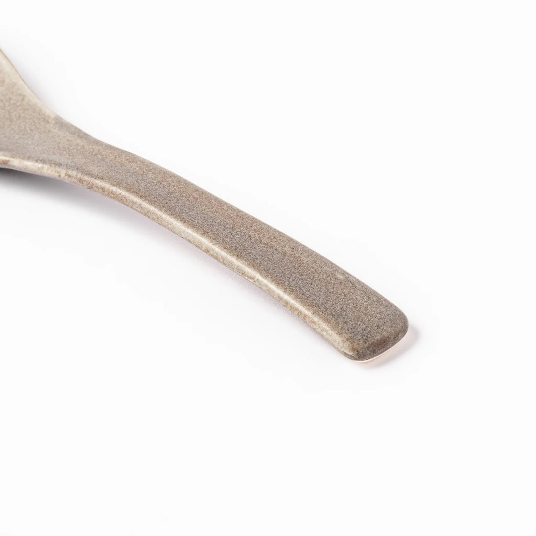Gray ceramic spoon with a wide, curved bowl and gently angled handle, designed for smooth scooping of soups, stews, and curry dishes.