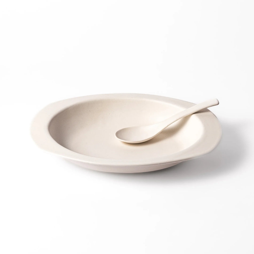 White oval ceramic curry plate with a wide rim and curved sides, designed for smooth scooping and serving of curry, rice, or pasta dishes.